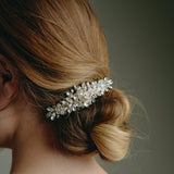 Bridal hair comb with silver crystals and freshwater pearls worn by a bride with a low bun updo