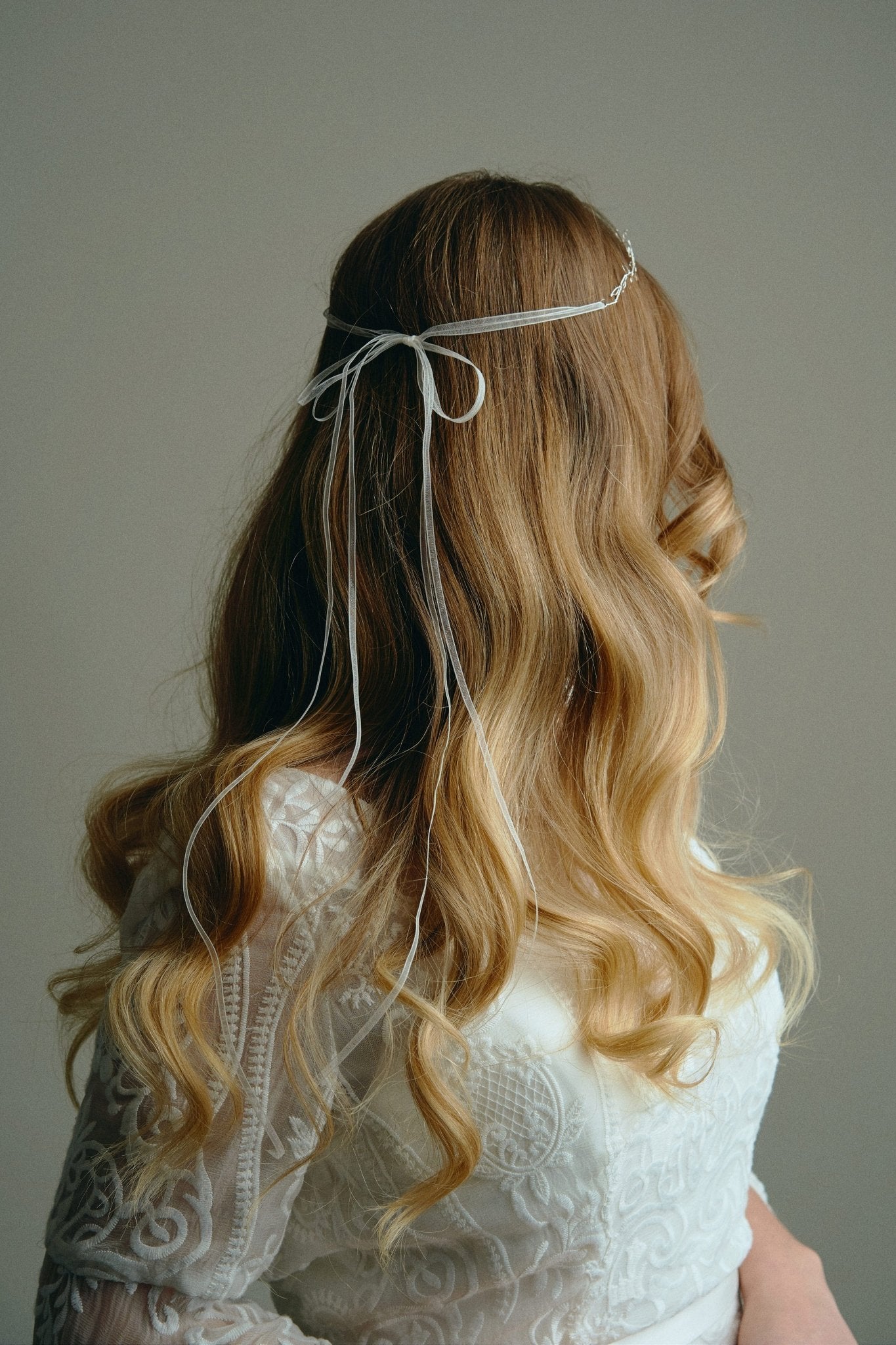 Model wears delicate silver leaf ribbon tie headband hair vine with long lose waves