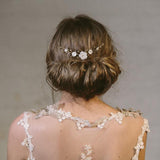 Rustic comb worn above a low bun with ivory flowers with gold crystals 