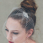 Short birdcage veil styled with small crystal comb