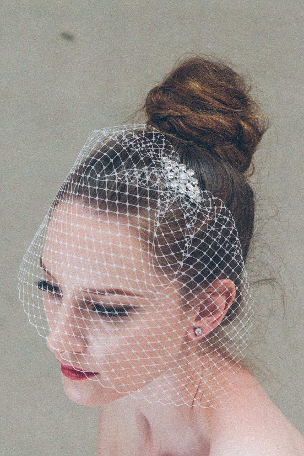Short birdcage veil styled with small crystal comb
