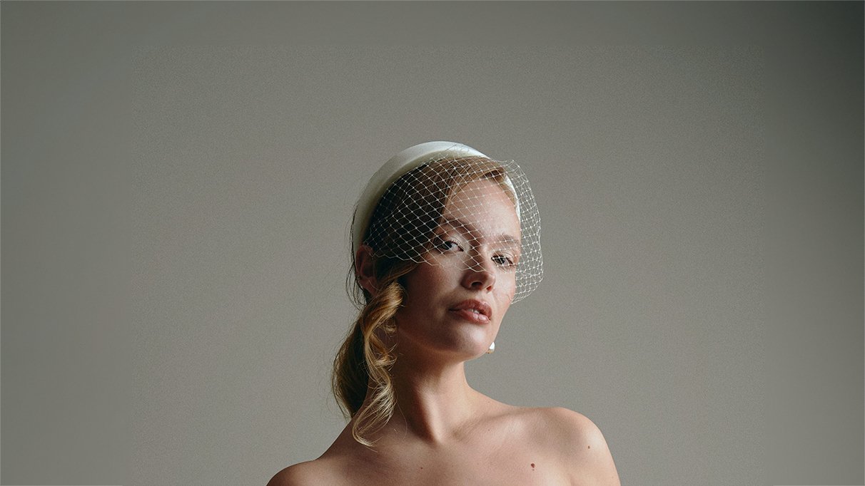 Bride wears a birdcage veil with padded headband