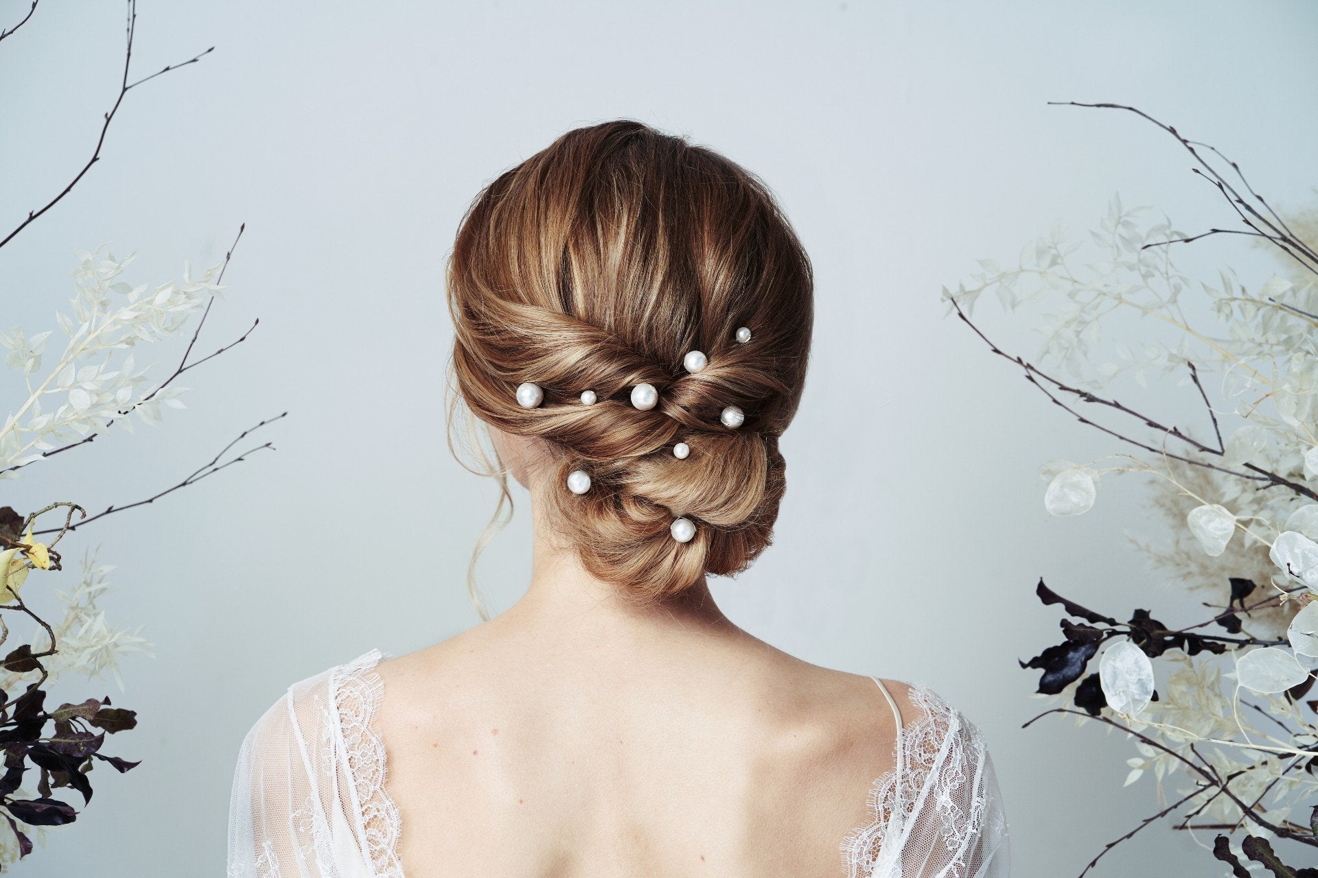 How to shop for your bridal hair accessories - model wears mixed size pearl hairpins scattered through a twisted low bun