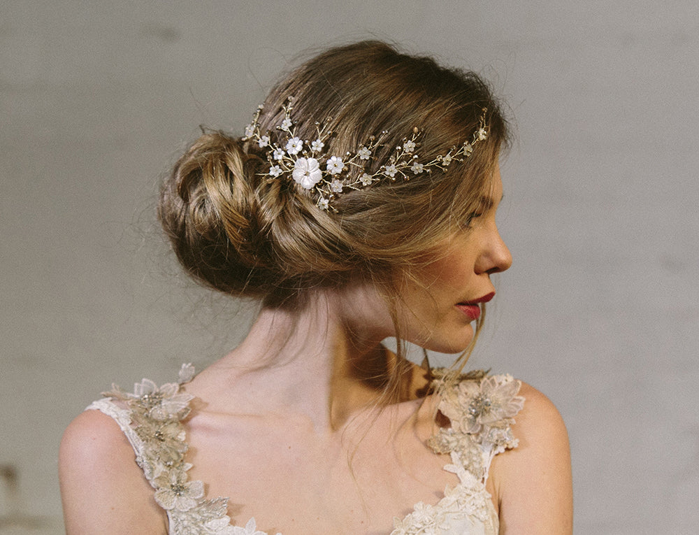 bride wears gold and ivory boho wedding hair vine on a comb with a loose relaxed updo
