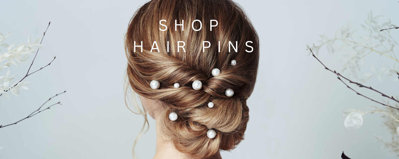 bride wears mixe size pearl hairpins in twisted low bun updo