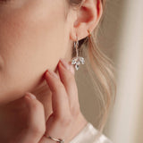 Close-up of a woman wearing a silver crystal earring