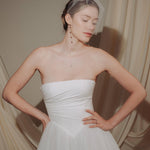bride wears a sheer tulle birdcage style veil with long drop pearl earrings and a baroque coin pearl necklace