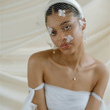 Betsy Ivory Birdcage Veil With 3D Silk Flowers worn with the Esther ivory satin padded headband