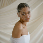 A black bride wears a full gathered birdcage veil