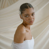 A black bride wears a full gathered birdcage veil