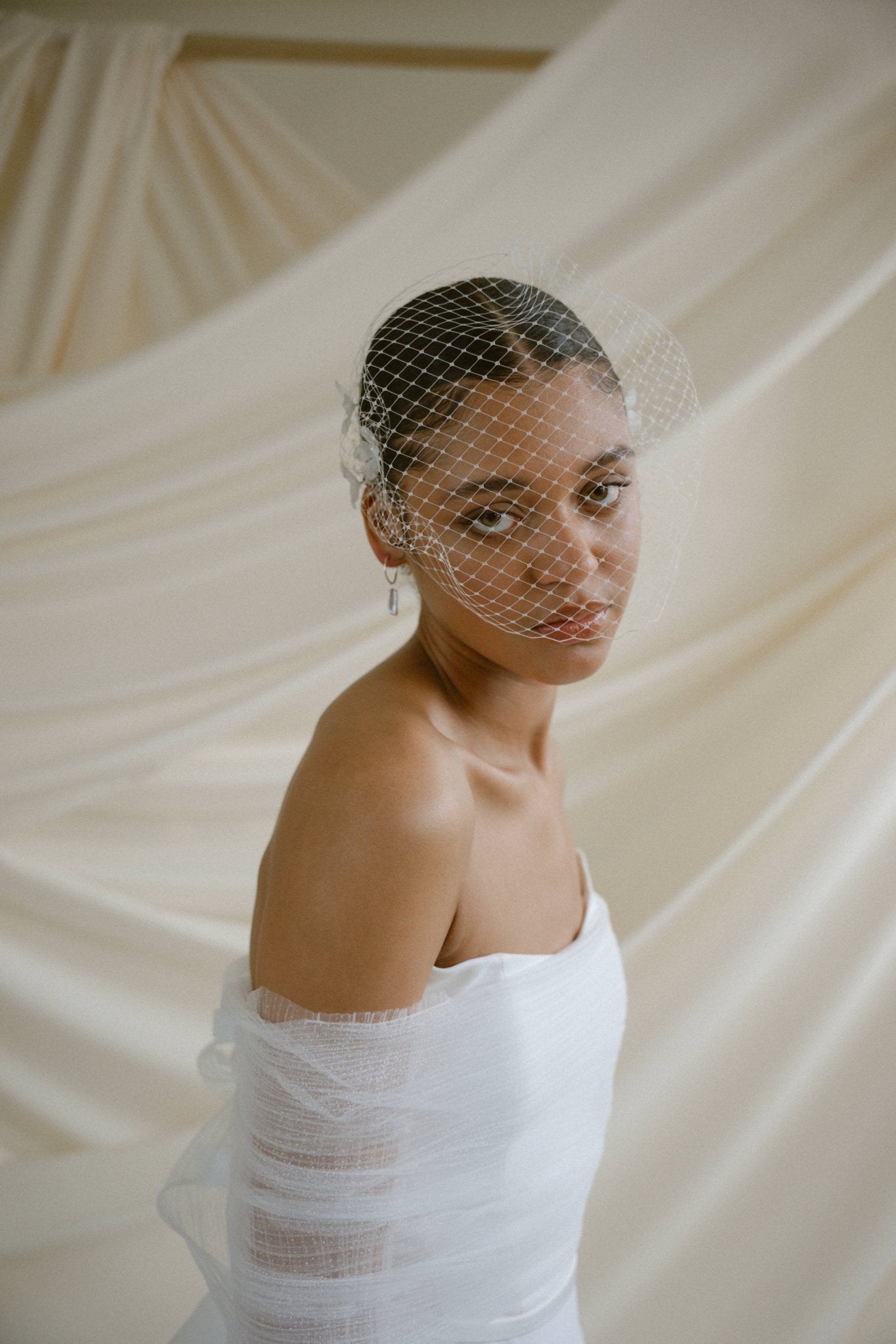 A black bride wears a full gathered birdcage veil
