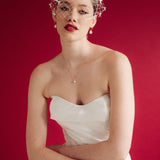 bride wears a bow birdcage veil on a slim headband