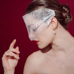 bride wears a sheer chantilly lace mask micro veil with gold hoop vegan baroque pearl earrings
