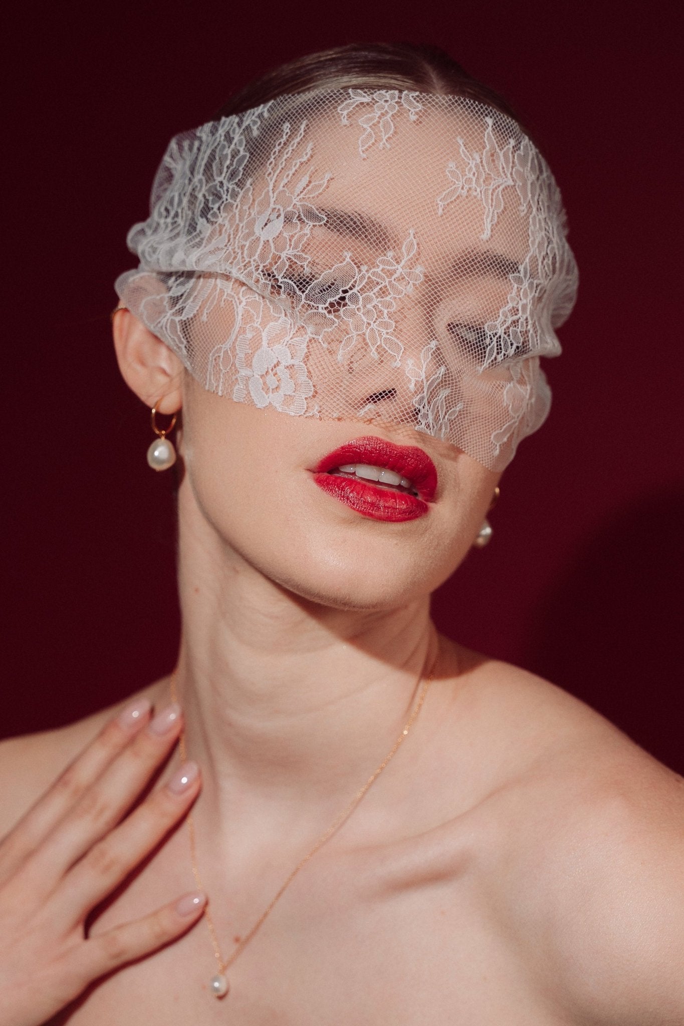 Bride wearing a lace veil and gold hoop earrings with a single vegan baroque pearl