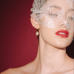 bride wears a sheer chantilly lace mask micro veil with gold hoop vegan baroque pearl earrings  and matching necklace