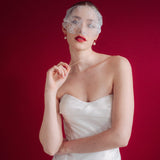 bride wears a sheer chantilly lace mask micro veil with gold hoop vegan baroque pearl earrings