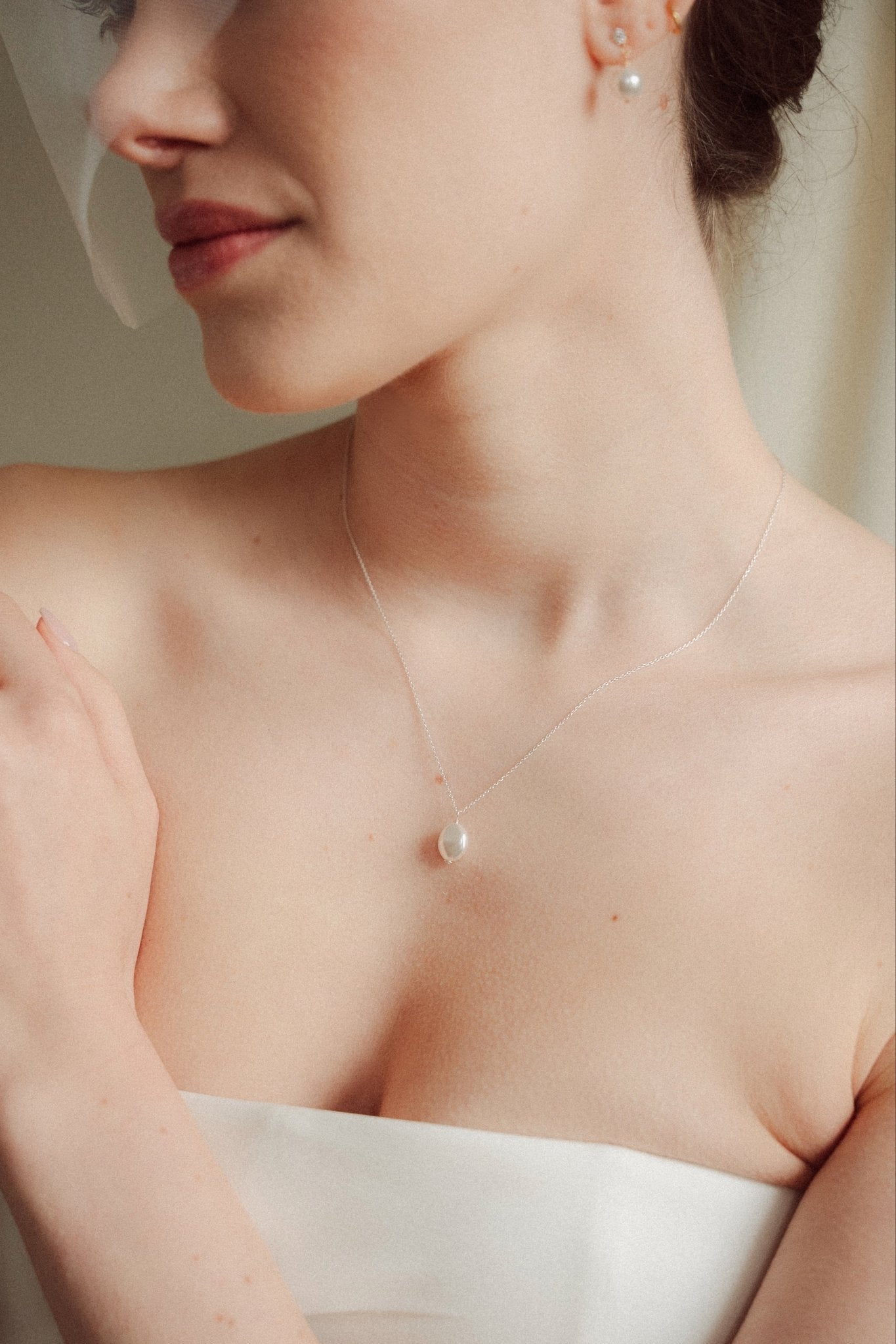bride wears a silver baroque coin vegan pearl necklace