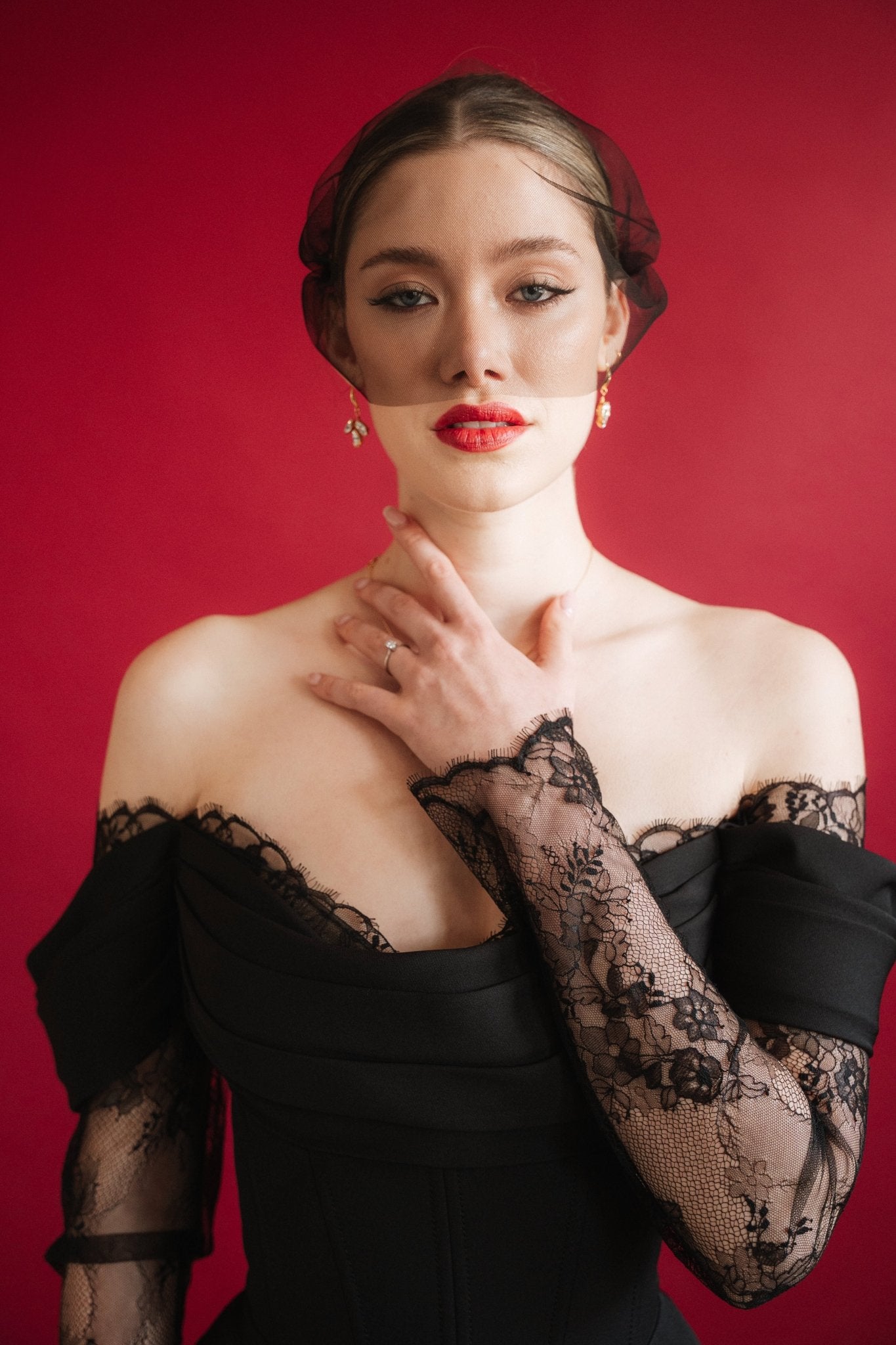 bride wears a gold baroque coin vegan pearl necklace, gold crystal drop earrings and a black tulle mask veil micro veil with a black lace dress