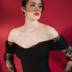 bride wears a gold baroque coin vegan pearl necklace, gold crystal drop earrings and a black tulle mask veil micro veil with a black off the shoulder gown 