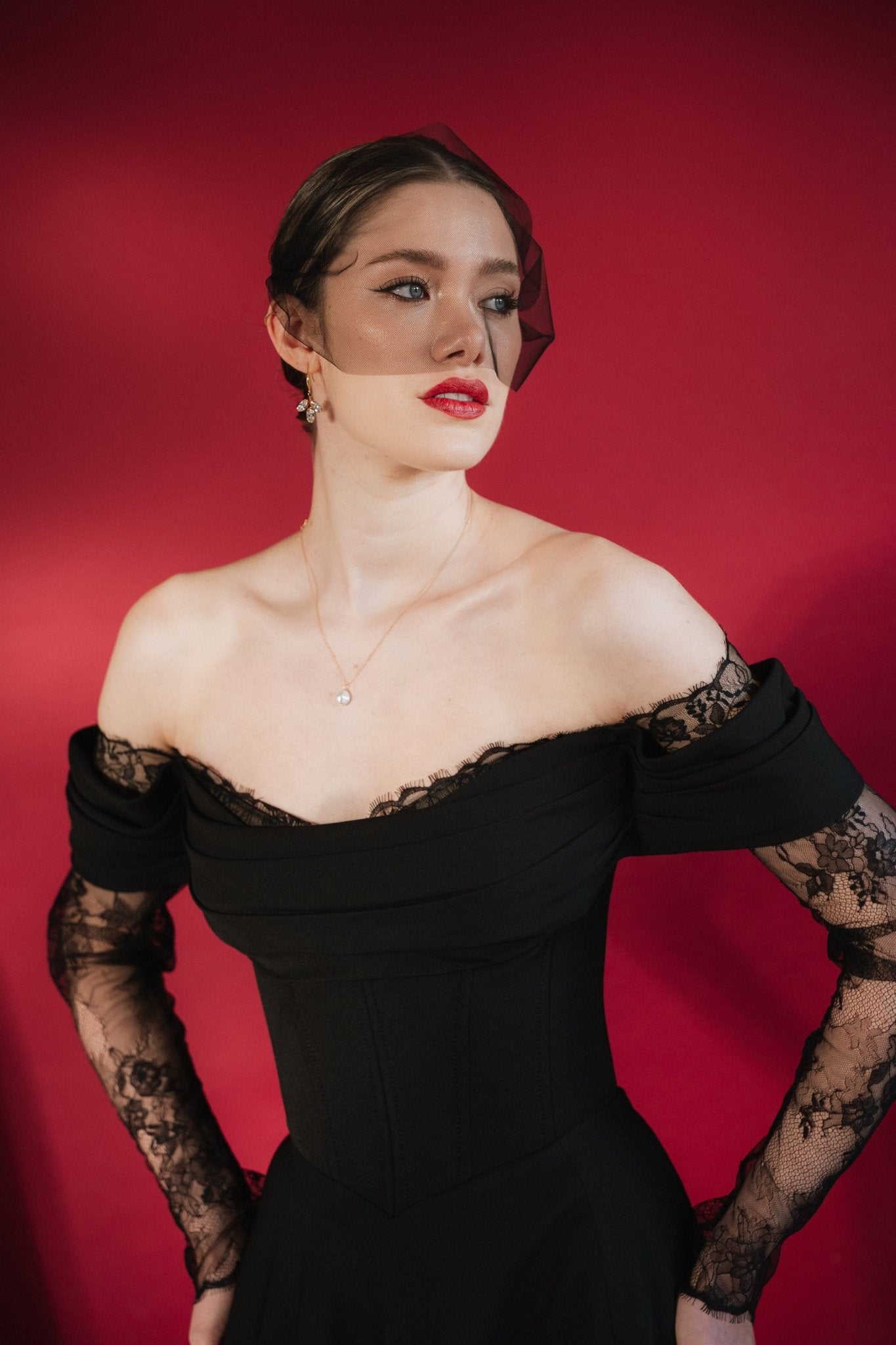 bride wears a gold baroque coin vegan pearl necklace, gold crystal drop earrings and a black tulle mask veil micro veil with a black off the shoulder gown 