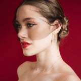 bride wears a gold baroque coin vegan pearl necklace, gold crystal drop earrings and a black tulle mask veil micro veil