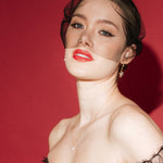 bride wears a gold baroque coin vegan pearl necklace, gold crystal drop earrings and a black tulle mask veil micro veil with black lace gown