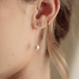 Close-up of a bride wearing a delicate crytal and pearl drop earring in silver with a pearl and crystal cluster pearl comb