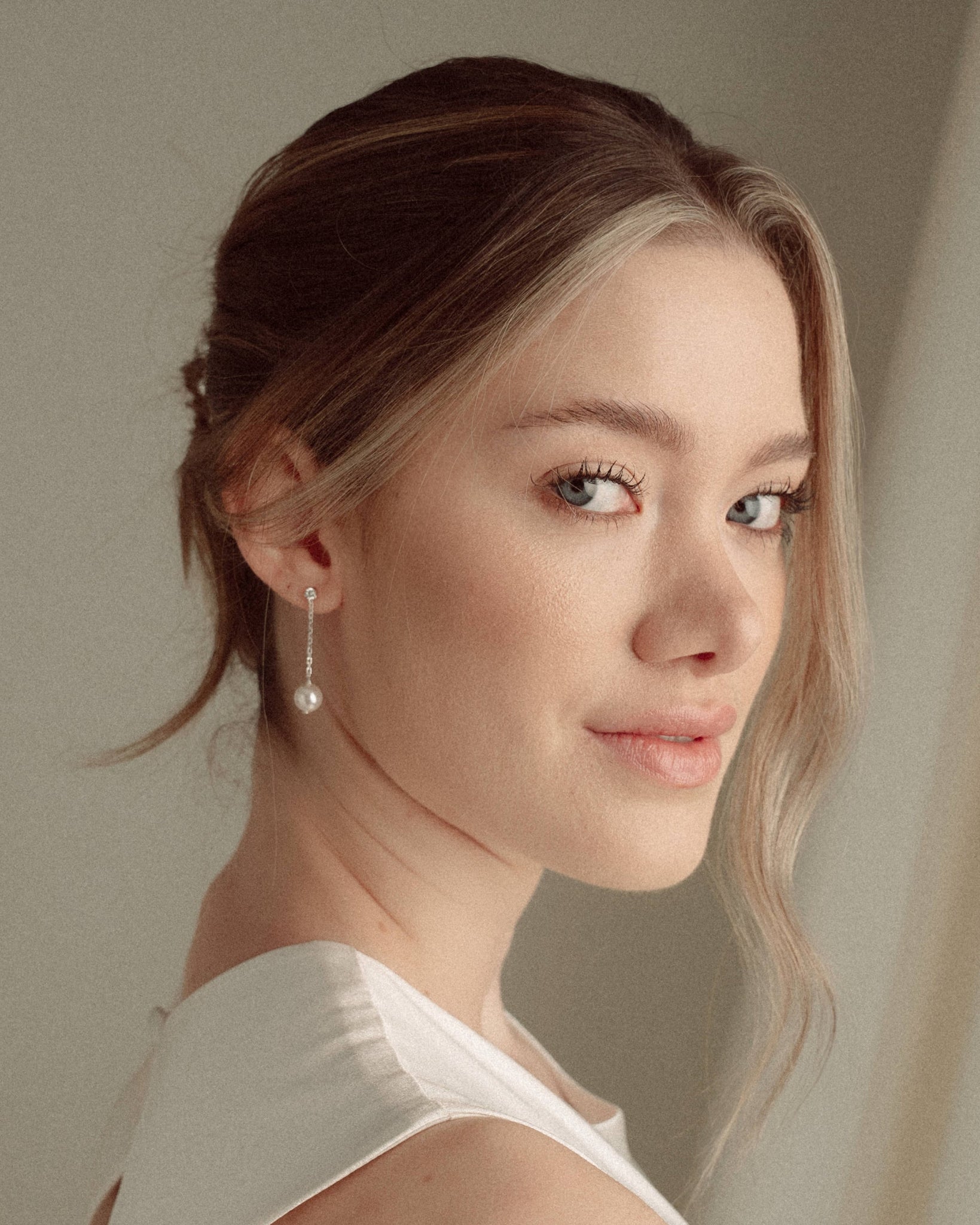 Bride with a low updo wearing the Ina silver pearl drop earrings