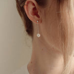 Close-up of a bride wearing a delicate crytal and pearl drop earring silver