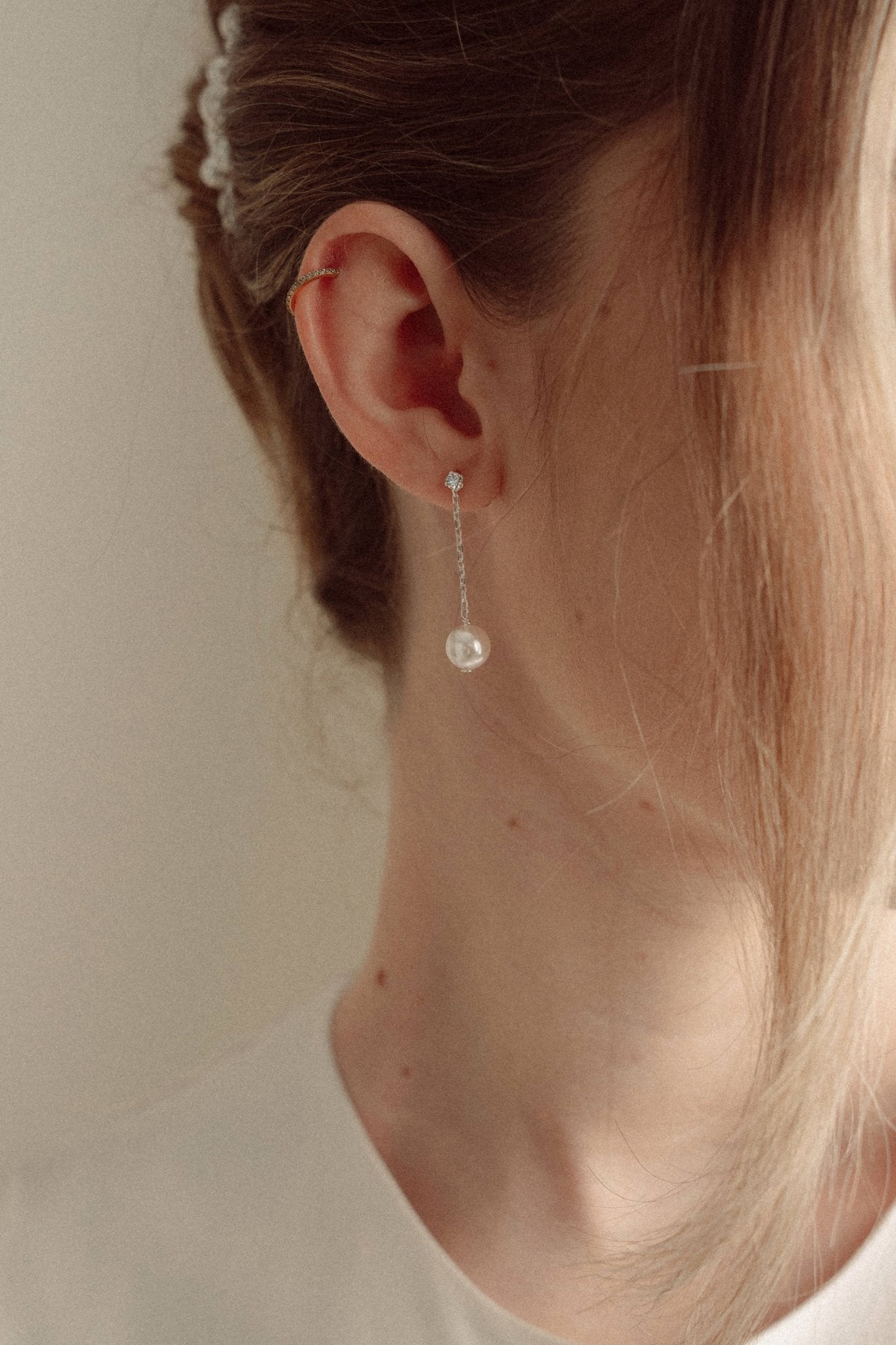 Close-up of a bride wearing a delicate crytal and pearl drop earring silver