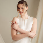 Bride wears pearl and crystal stud drop earrings with a small silver crystal comb with an elegant chignon updo
