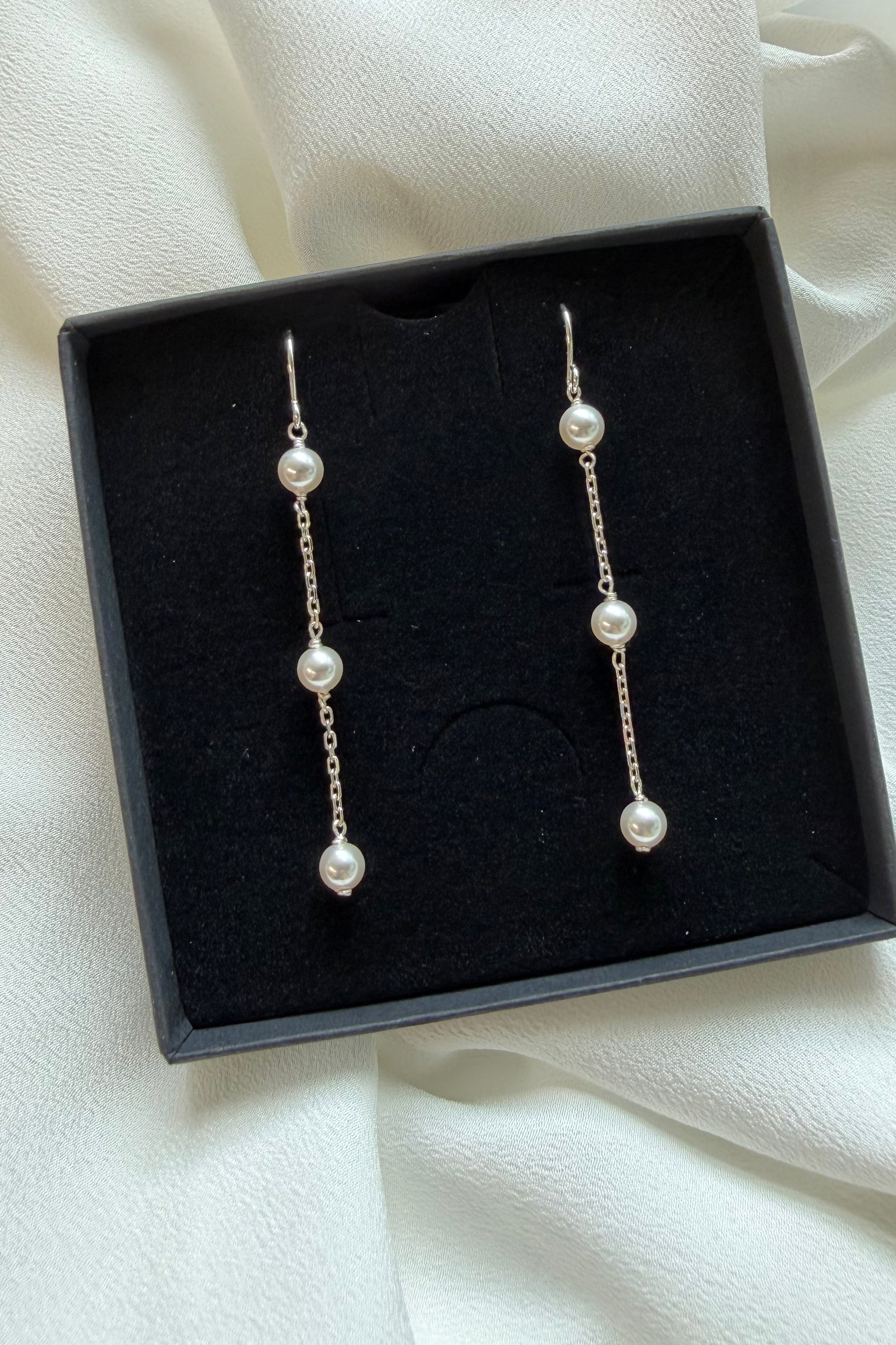 Close-up of Thea three-pearl drop earring in silver