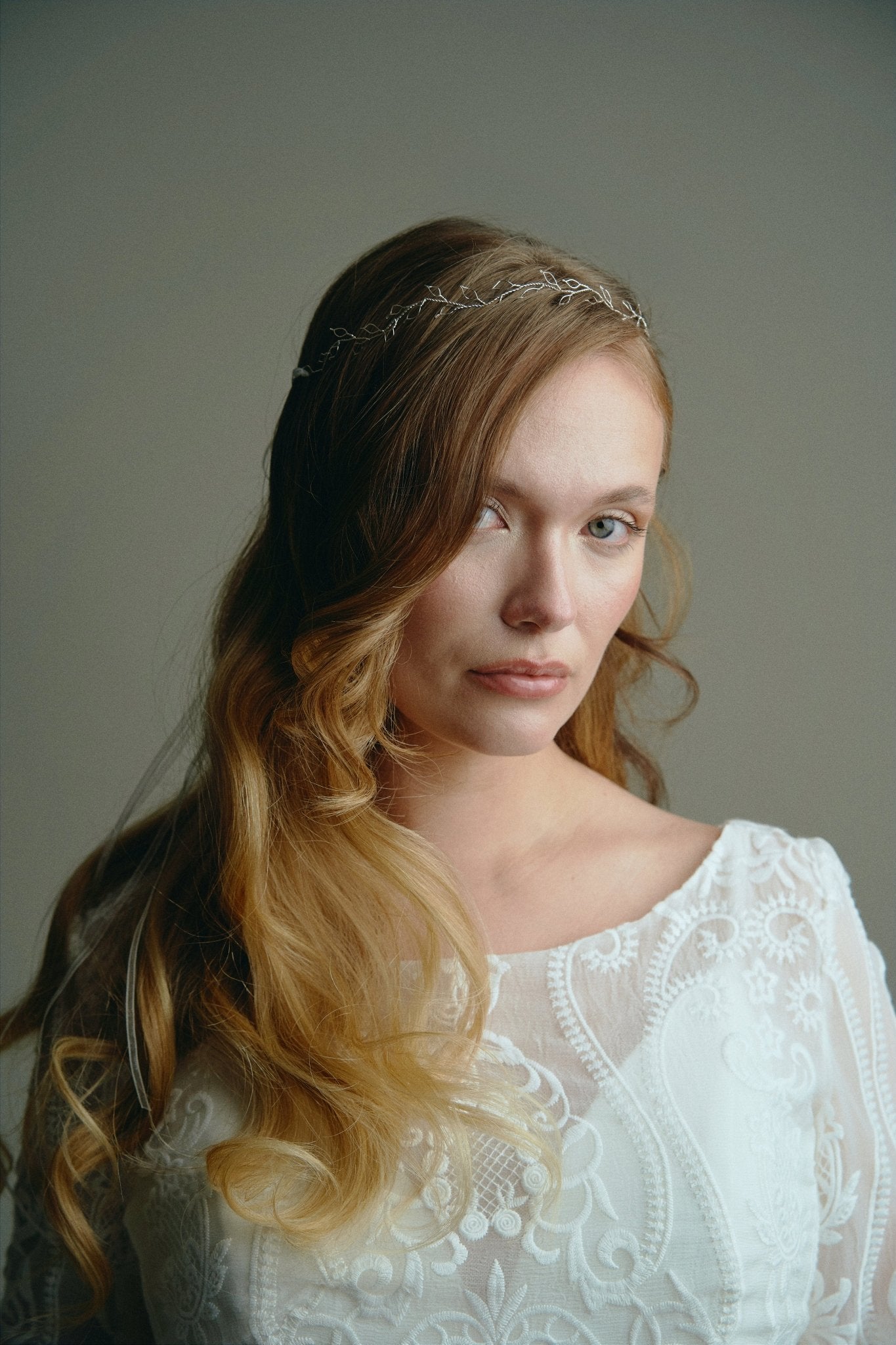 Model wears delicate silver leaf ribbon tie headband hair vine with long lose waves