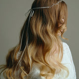 Model wears delicate silver leaf ribbon tie headband hair vine with long lose waves