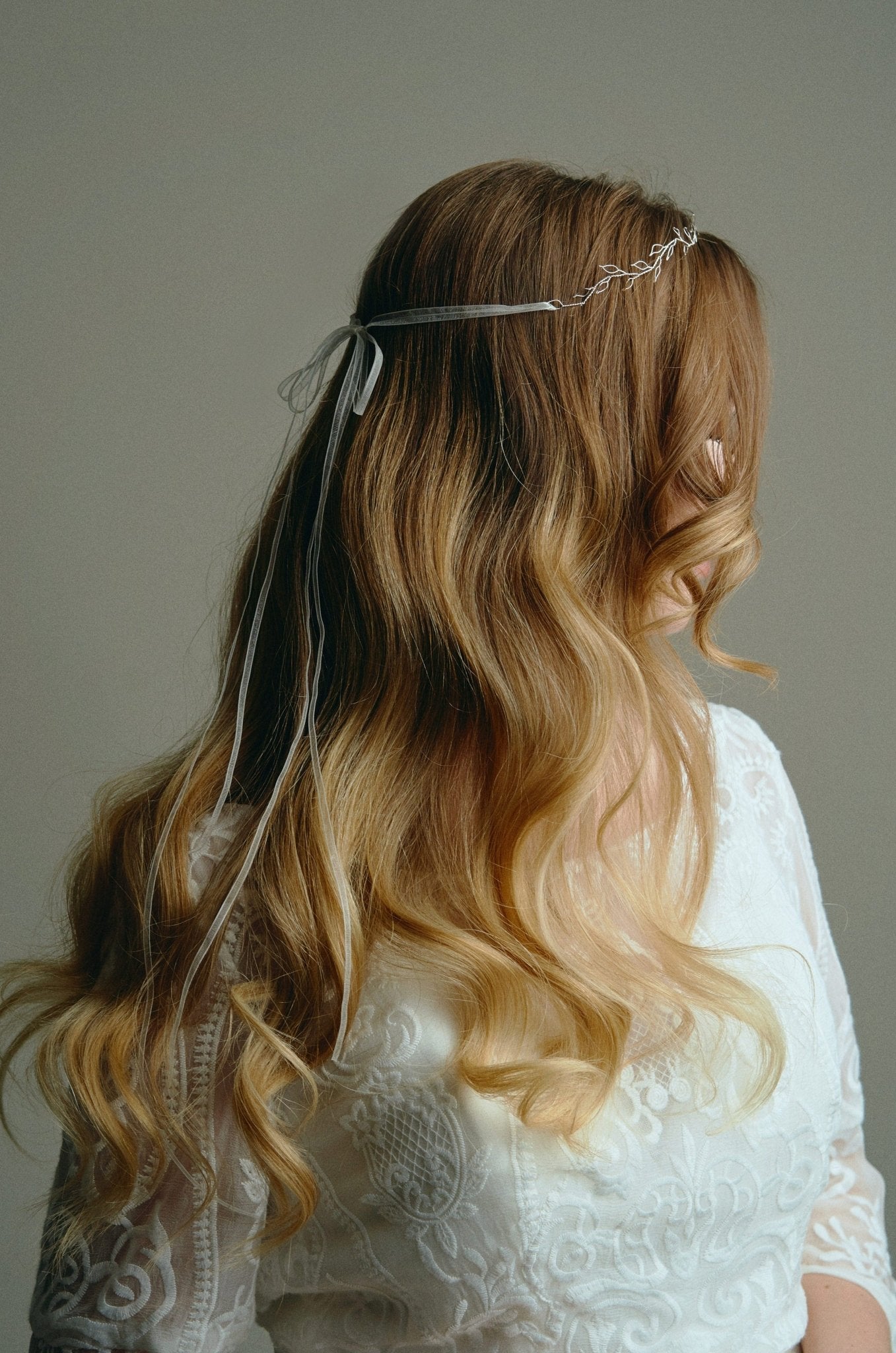 Model wears delicate silver leaf ribbon tie headband hair vine with long lose waves