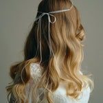 Model wears delicate silver leaf ribbon tie headband hair vine with long lose waves