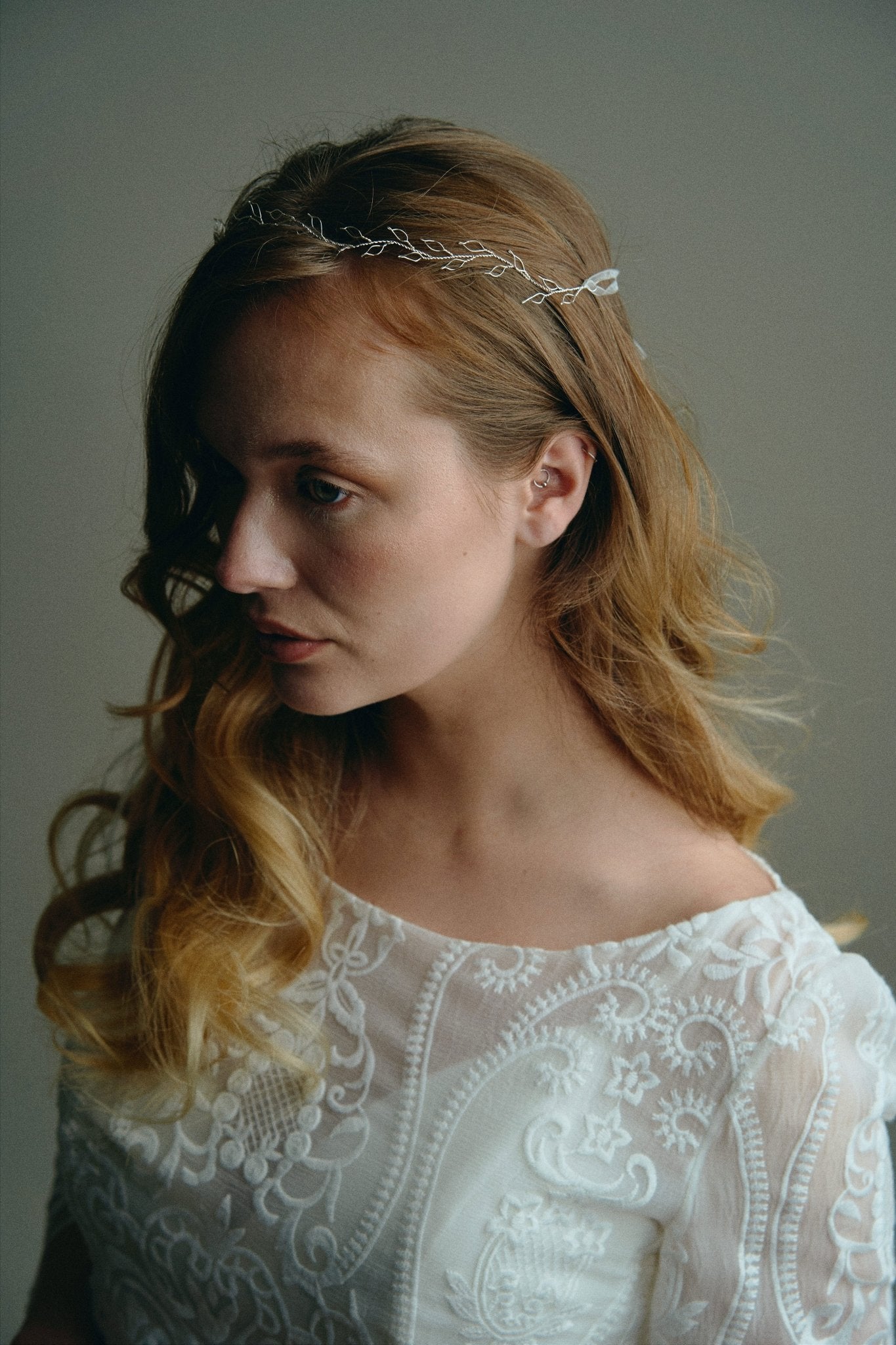 Model wears delicate silver leaf ribbon tie headband hair vine with long lose waves