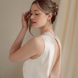 Bride wears pearl cluster earrings and crystal and perl delicate drop earrings  with a silk gown and soft romantic chignon updo