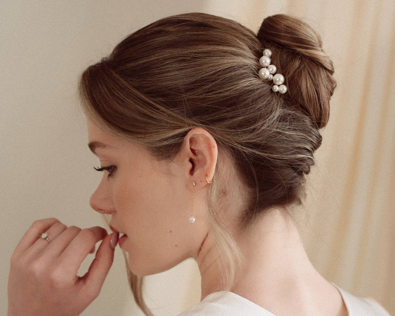 Bride wearing Ina gold crystal and pearl drop earrings with Perla cluster pearl hair pins and a silk gown