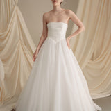 Bride wears an ivory tulle veil with face-framing silk flowers with coordinating silk flower and pearl long drop earrings