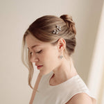 An elegant bride wears silver crystal drop earrings with matchching crytal hair pins