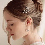 An elegant bride wears silver crystal drop earrings with matchching crytal hair pins