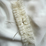 Lace garter with a bow on a soft white fabric background