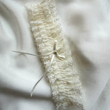 Lace garter with a bow on a soft white fabric background