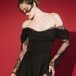 Woman in a black lace dress against a red background wears a black mask style micro veil with a lace edging