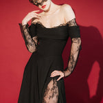 Woman in a black lace dress against a red background wears a black mask style micro veil with a lace edging