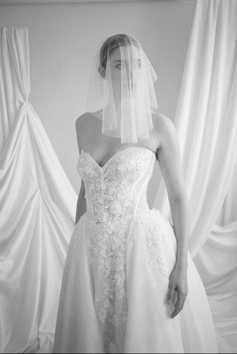 Bride wears a sheer tulle drop micro veil with pearl and crystal embellishments 