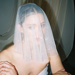 Bride wears a sheer tulle drop micro veil with pearl and crystal embellishments 