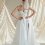 Bride wears a sheer tulle drop micro veil with pearl and crystal embellishments 