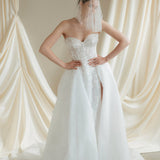 Bride wears a sheer tulle drop micro veil with pearl and crystal embellishments 